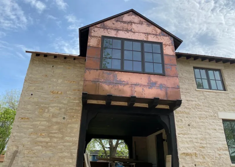 Copper metal panel facade on a stone building for Roof Repair in Madison